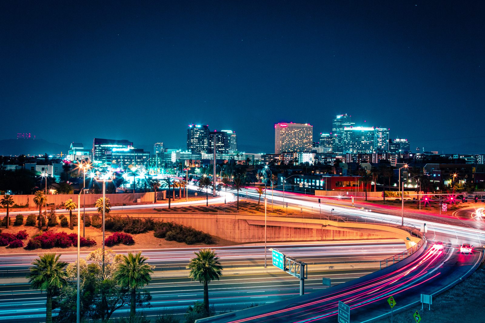 Phoenix freeway light trails at night with the downtown skyline behind