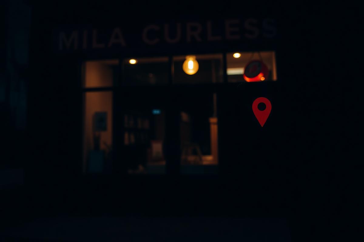 Small business storefront at night with a location pin marker