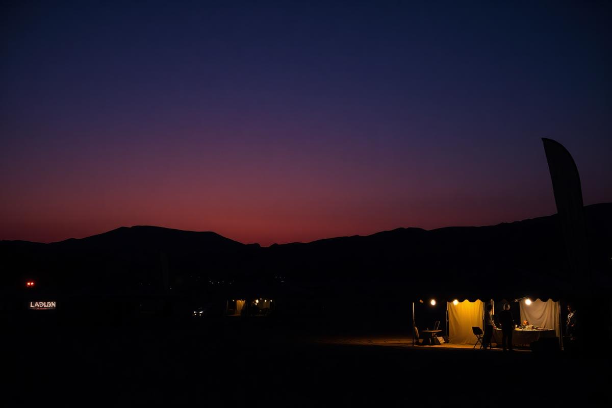 Sponsor tents at a desert race venue at dusk