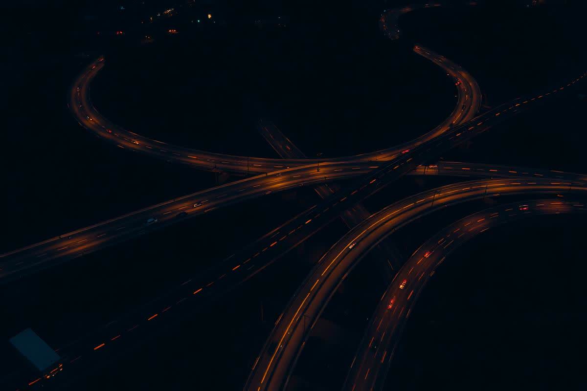Aerial view of a freeway interchange at night with traffic light trails