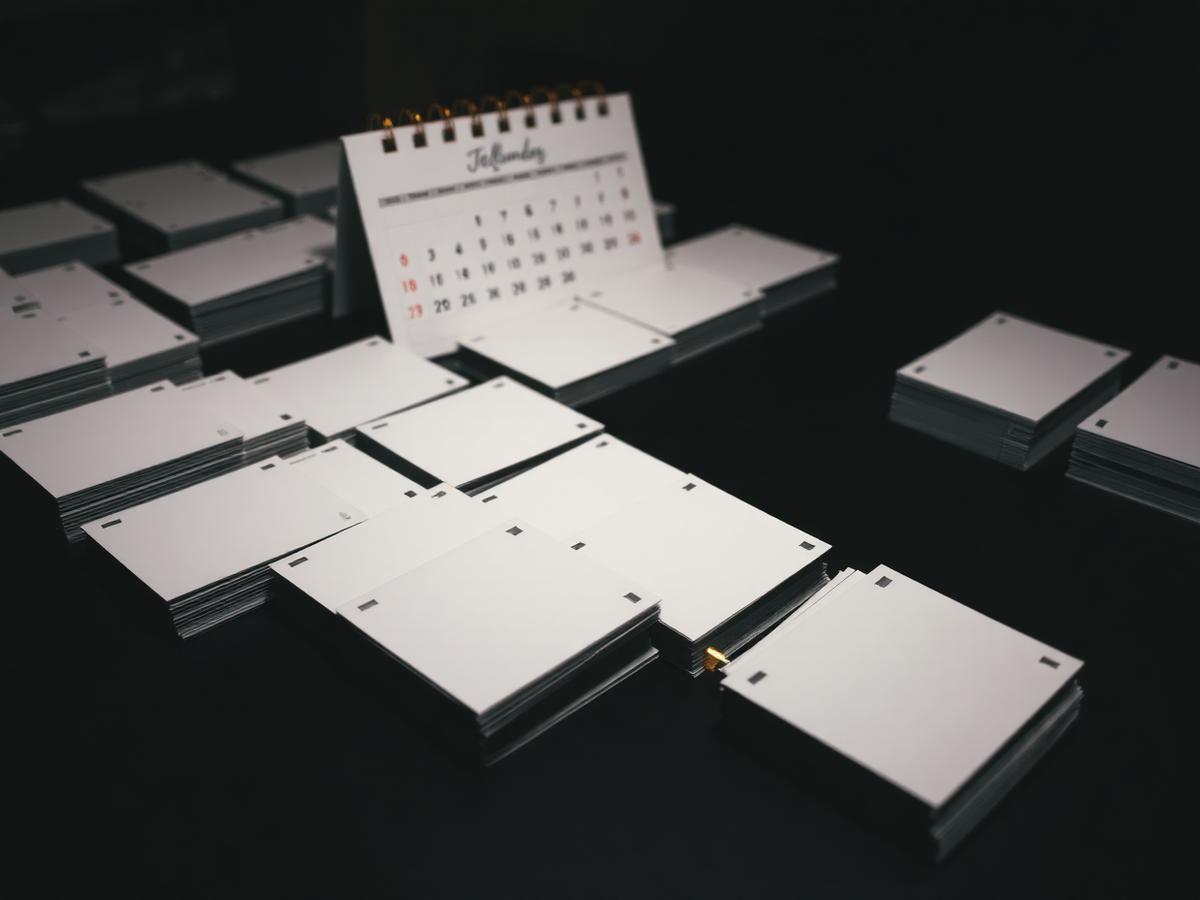 Stacks of postcards arranged in repeating waves beside a calendar