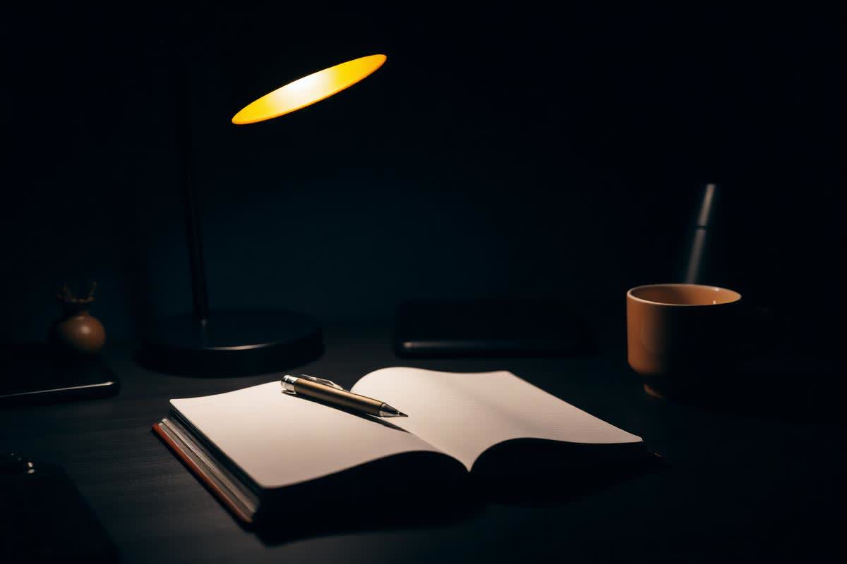 Lamp-lit desk at night where a Phoenix ad account is planned