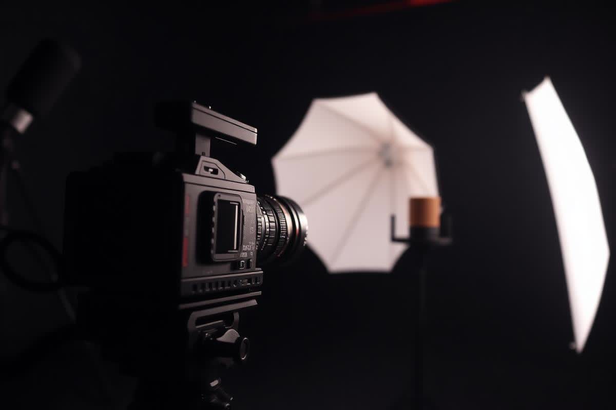 Cinema camera and lighting on a dark studio set producing ad creative